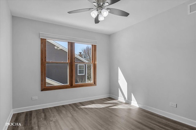 empty room featuring visible vents, baseboards, and wood finished floors