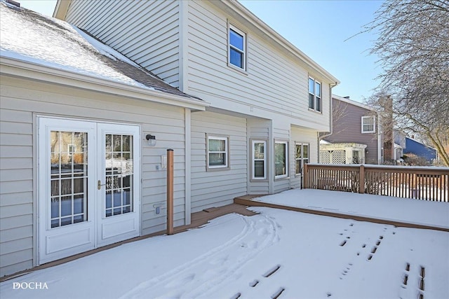 snow covered property with french doors