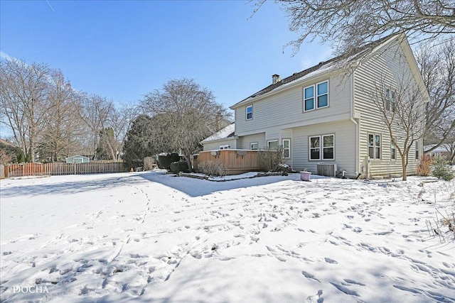 snow covered property featuring central AC unit, fence, and a deck