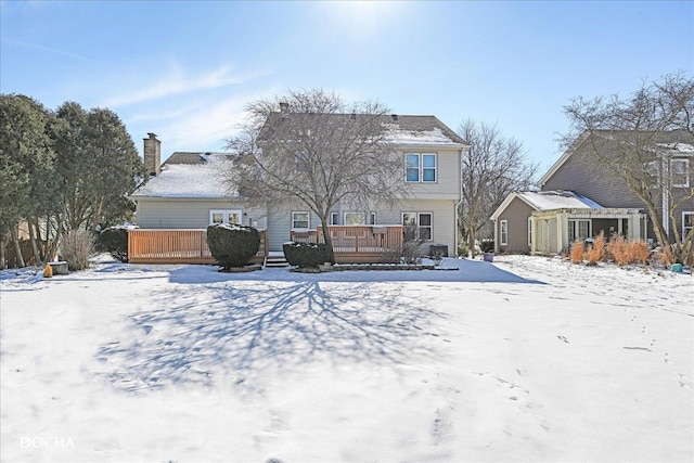 snow covered house featuring a deck