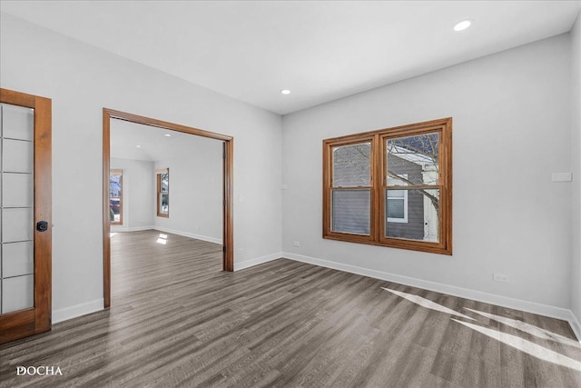 empty room featuring recessed lighting, wood finished floors, and baseboards