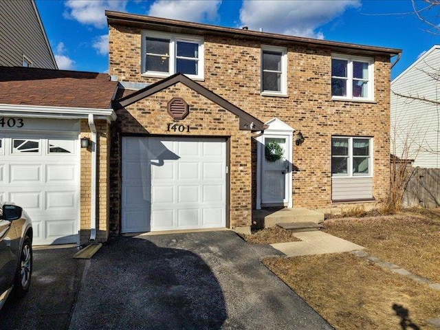 view of front of property featuring a garage, brick siding, fence, and aphalt driveway