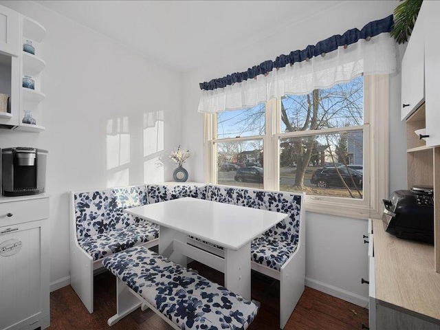 dining area featuring breakfast area, dark wood finished floors, and baseboards