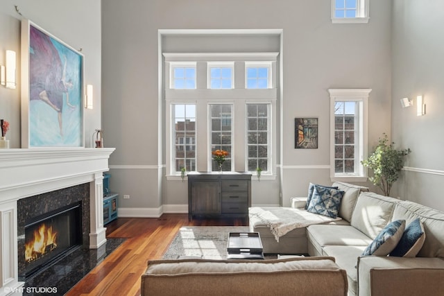 living room with a premium fireplace, wood finished floors, and baseboards