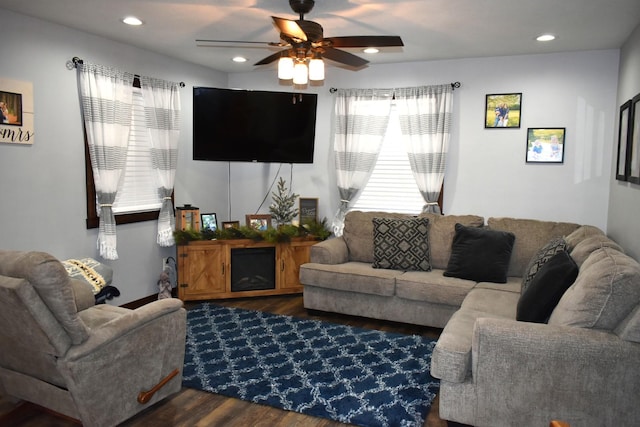 living area featuring ceiling fan, a fireplace, dark wood-style flooring, and recessed lighting