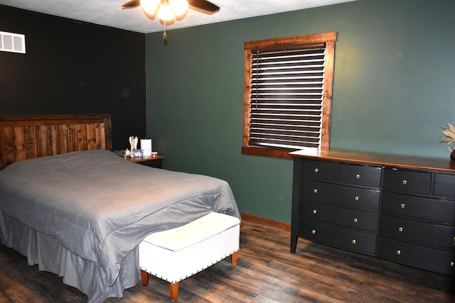 bedroom featuring a ceiling fan, visible vents, baseboards, and wood finished floors