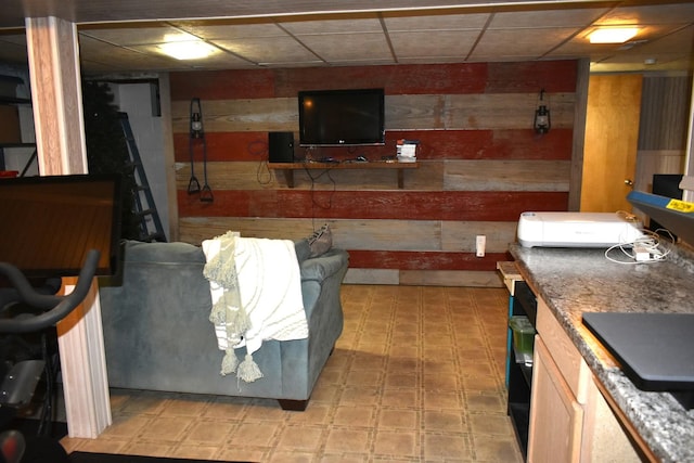 bar with wood walls, a drop ceiling, and light floors