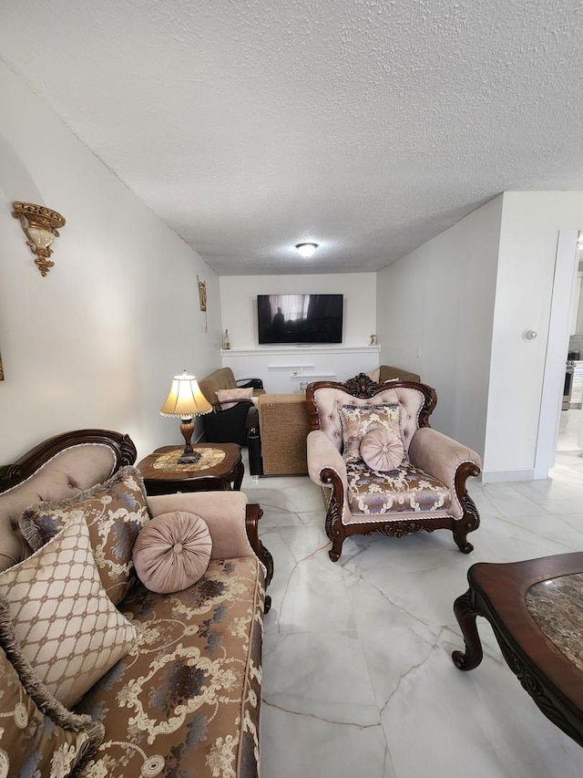 living room featuring marble finish floor and a textured ceiling