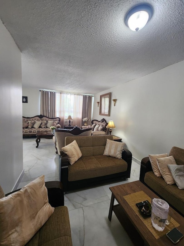 living area featuring marble finish floor and a textured ceiling