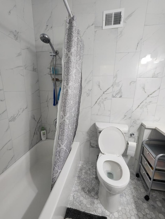 full bath featuring toilet, visible vents, shower / bath combo with shower curtain, and tile walls