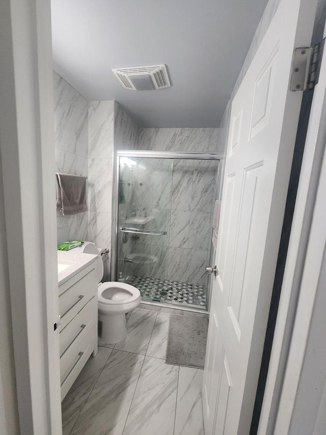 full bathroom with a marble finish shower, visible vents, toilet, marble finish floor, and vanity