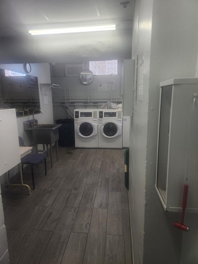 common laundry area featuring a sink, wood tiled floor, and washer and dryer