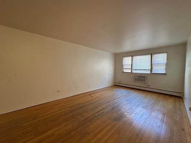 empty room featuring a baseboard radiator and wood finished floors