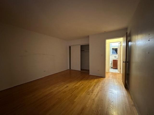 unfurnished bedroom featuring a closet and light wood-style flooring