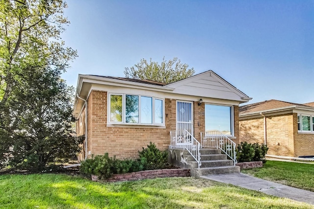 view of front of house with brick siding and a front yard