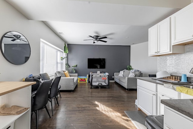 living room featuring dark wood-style flooring and a ceiling fan