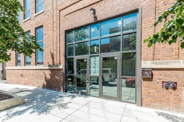 entrance to property featuring french doors and brick siding