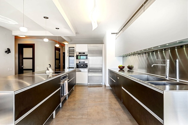 kitchen featuring stainless steel countertops, modern cabinets, pendant lighting, and stainless steel appliances