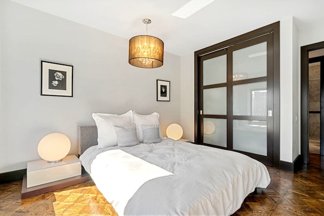 bedroom featuring an inviting chandelier and baseboards