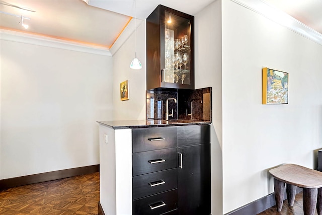 bar featuring baseboards, ornamental molding, and indoor wet bar