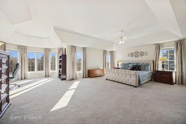 bedroom with a ceiling fan, a raised ceiling, carpet flooring, and crown molding