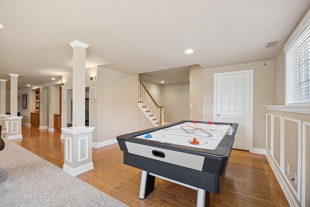 recreation room with visible vents, wood finished floors, recessed lighting, baseboards, and ornate columns