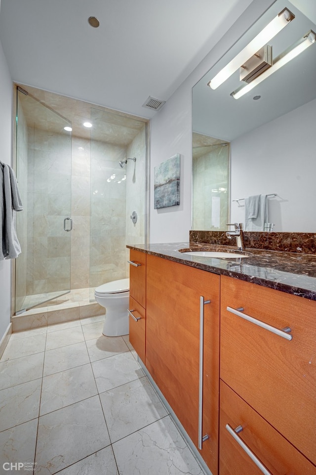 bathroom with visible vents, vanity, toilet, and a shower stall