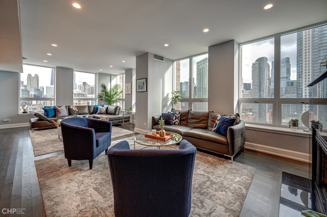 living room with recessed lighting, a city view, a healthy amount of sunlight, and wood finished floors