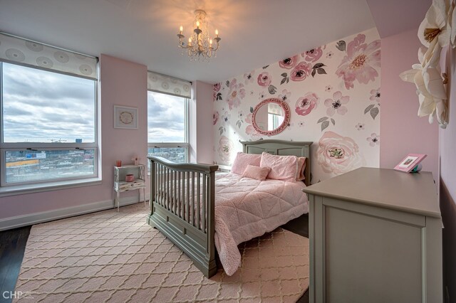 bedroom featuring wallpapered walls, baseboards, and a chandelier