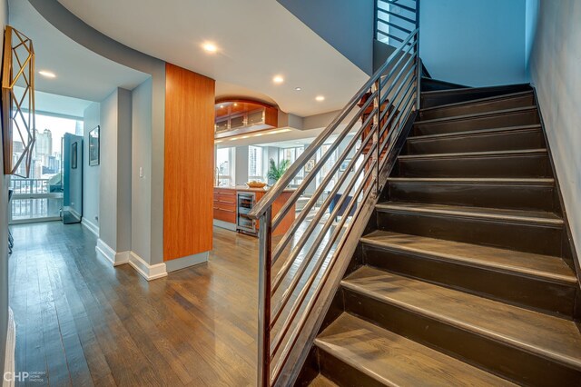 stairs featuring beverage cooler, recessed lighting, baseboards, and wood finished floors