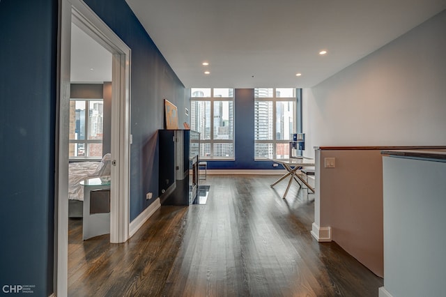 corridor featuring dark wood finished floors, plenty of natural light, and recessed lighting