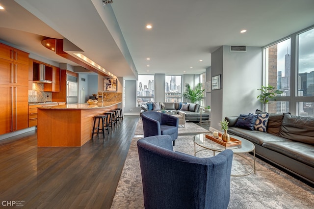 living room featuring visible vents, a view of city, dark wood-style floors, recessed lighting, and a wall of windows