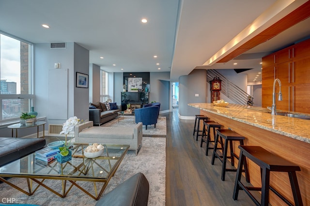 living area with visible vents, dark wood-style flooring, recessed lighting, baseboards, and stairs