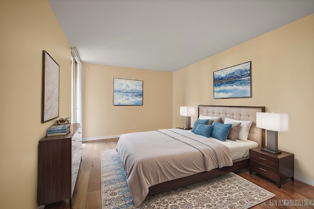 bedroom with baseboards and wood finished floors