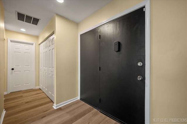 corridor with recessed lighting, baseboards, visible vents, and light wood finished floors