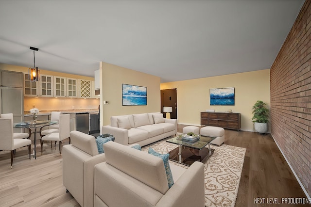 living area featuring brick wall and light wood-style floors