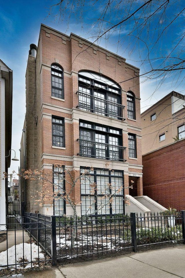 view of front facade featuring a fenced front yard and brick siding