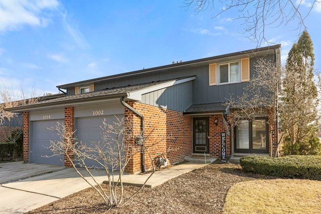 view of front of home featuring a garage, concrete driveway, and brick siding