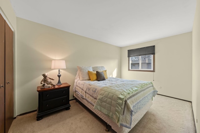 carpeted bedroom with a closet and baseboards