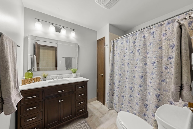 bathroom featuring toilet, a shower with shower curtain, vanity, and visible vents