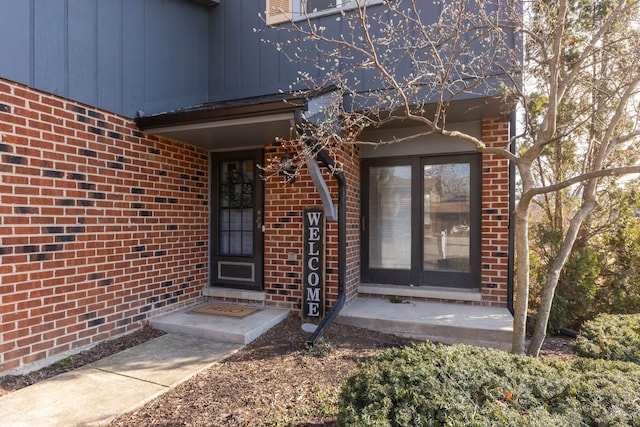 property entrance featuring brick siding and board and batten siding