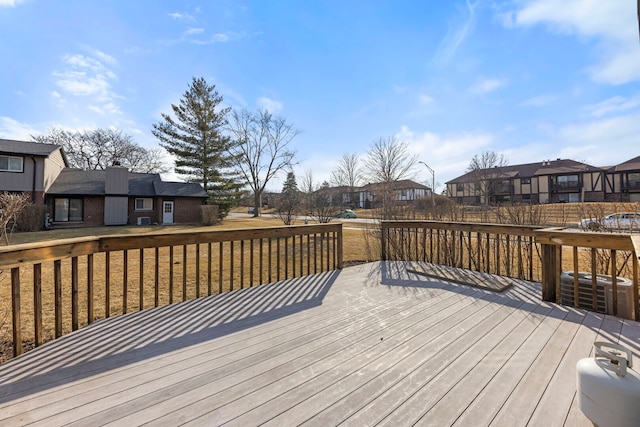 wooden deck featuring a residential view and cooling unit