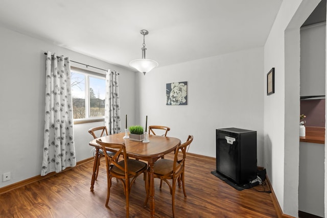 dining area featuring baseboards and dark wood finished floors