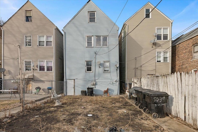 rear view of house featuring fence