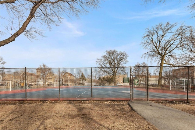 view of tennis court featuring fence and a gate