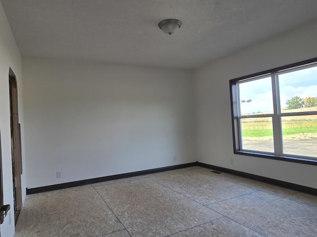 spare room featuring visible vents and baseboards