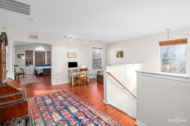 hall with dark wood-type flooring, plenty of natural light, an upstairs landing, and visible vents