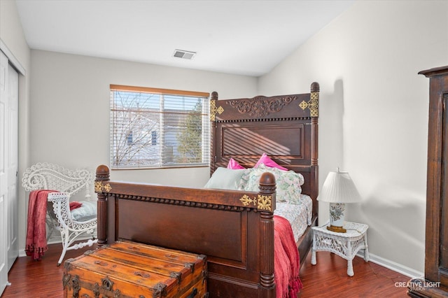 bedroom featuring dark wood-style floors, a closet, visible vents, and baseboards