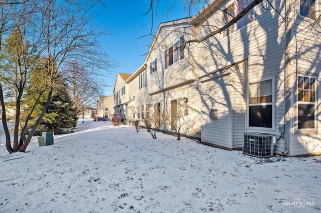 view of snow covered exterior with a residential view and cooling unit