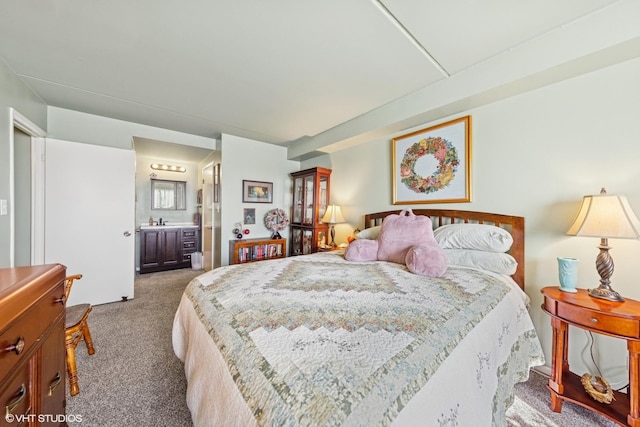 carpeted bedroom featuring a sink and ensuite bathroom